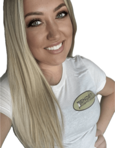 Woman smiling in white shirt with logo.